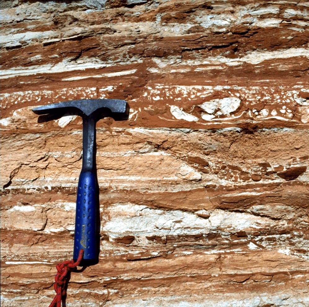 layered outcrop with hammer